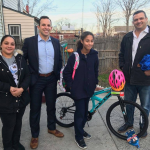 William Colarulo and Richard Grungo giving a kid a bike