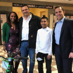 William Colarulo and Richard Grundo giving a kid a bike