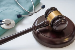 Judge’s gavel resting beside a stethoscope on a medical uniform, symbolizing nursing home abuse and medical negligence law.