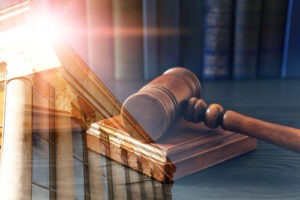 Gavel overlaid with a courthouse building, representing legal action and justice proceedings.