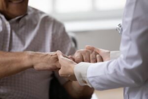 A doctor holding hand of an aged person