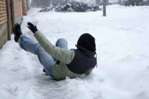  - a woman slips on an ice-covered sidewalk is a common winter hazard